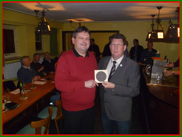 Der Vorsitzende der Schießabteilung des Bürger-Jäger-Corps Wolfgang Rössel bekommt vom Hauptmann des Neuen Bürger-Corps Frank Görmer seine Scheibe mit dem Schuß des Abends, einem 131 Teiler. 