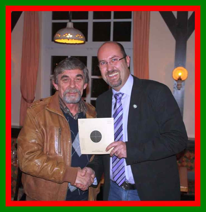 Adjutant Jens Hoffmann vom B&uuml;rger-J&auml;ger-Corps gratuliert Heinz Gr&auml;ser vom Peiner Walzwerker Verein zu seinem Schu&szlig; des Abends - einem 64 Teiler